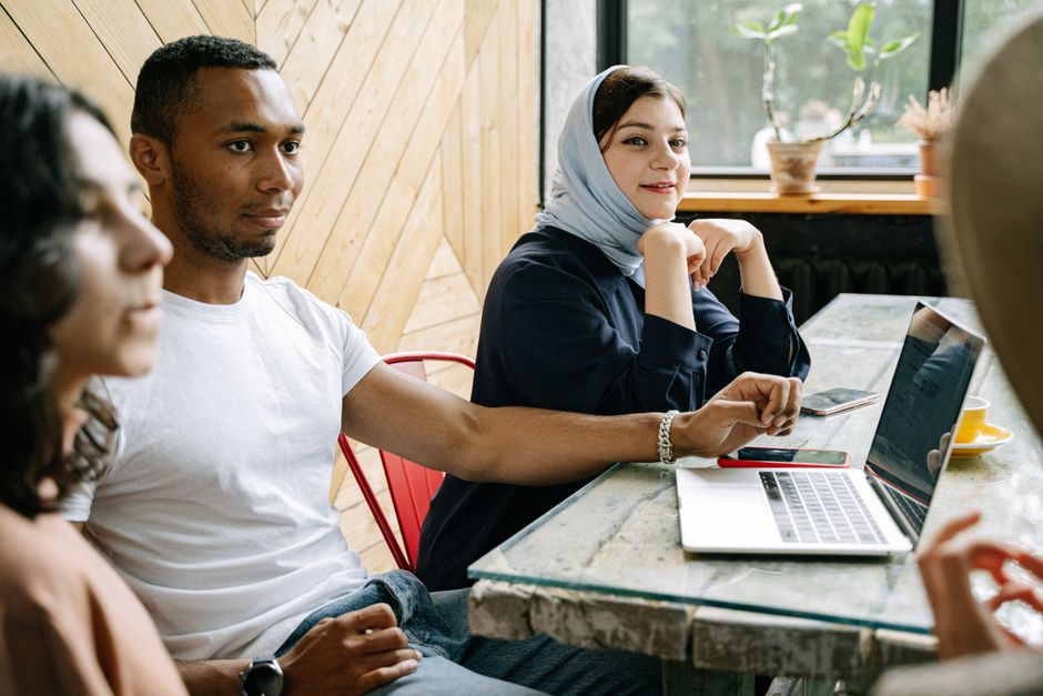 A diverse group of professionals engaged in collaborative work inside a modern workspace.